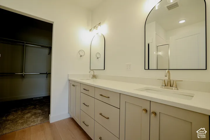 Dual vanity featuring light-toned cabinetry and integrated sinks with brushed nickel fixtures