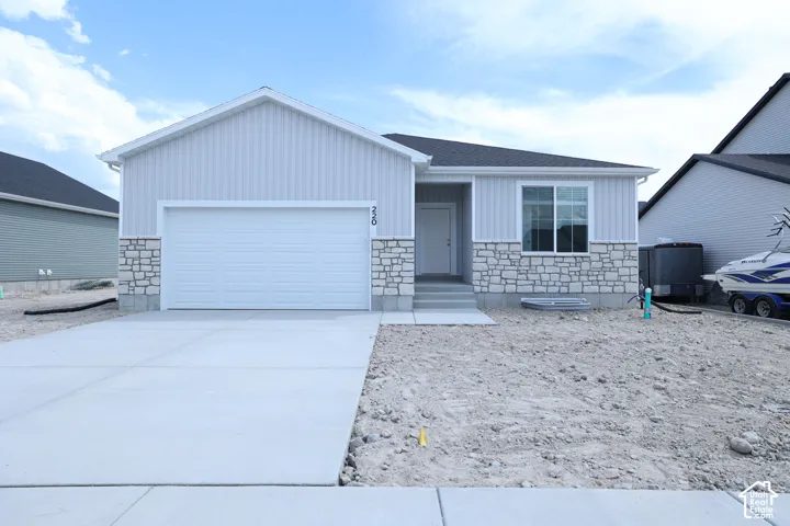Contemporary single-story residence featuring light gray vertical siding and a stone facade