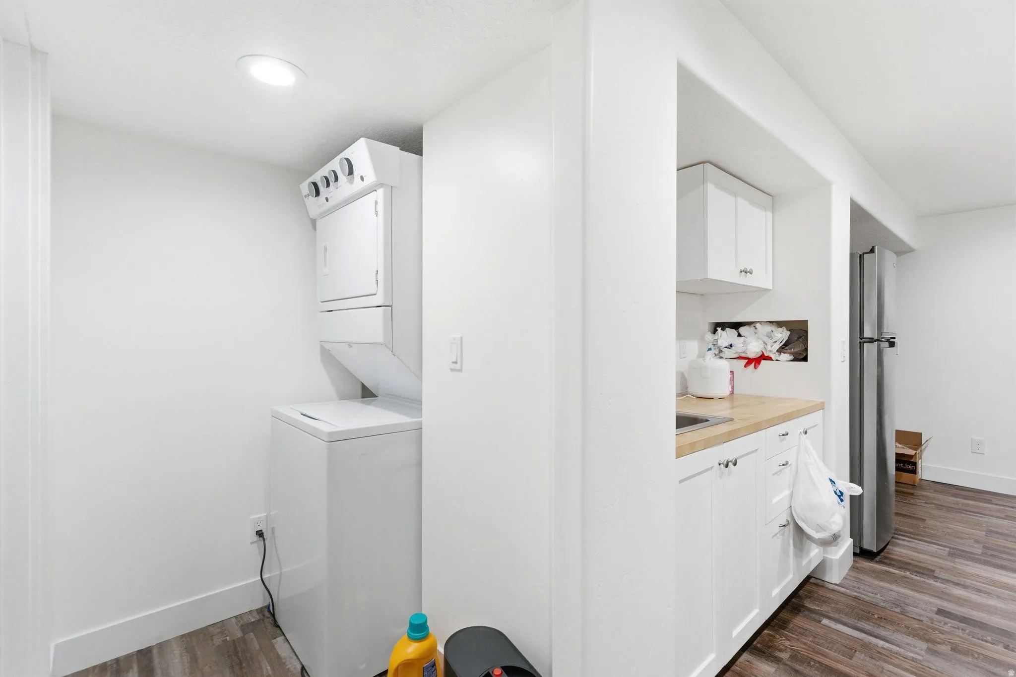 Dedicated laundry area featuring a stacked washer and dryer unit