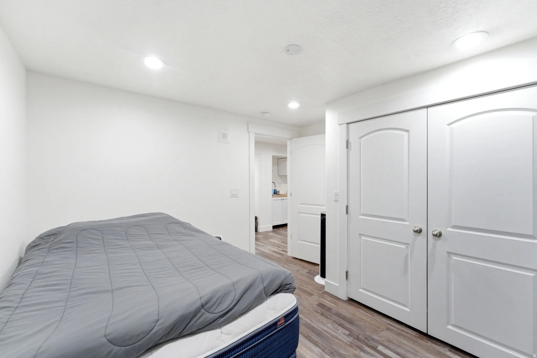 Room featuring wood-finish flooring, recessed lighting, and white walls