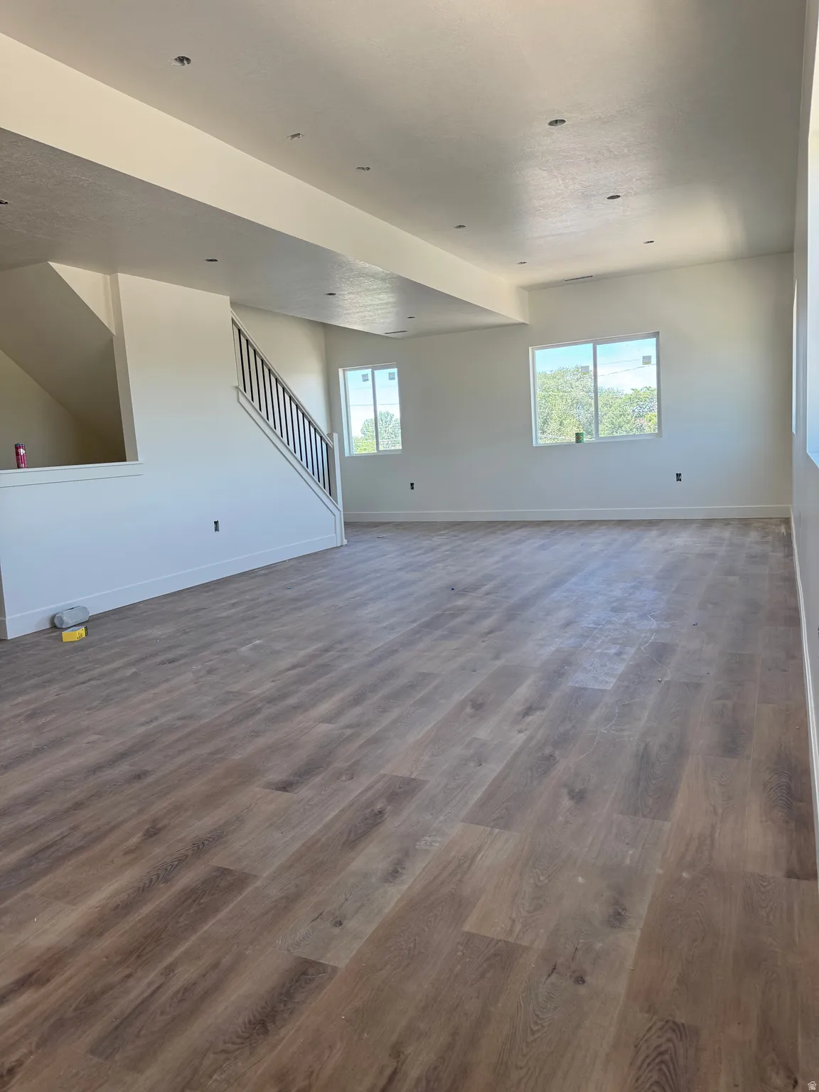 Spacious room featuring wood-finish flooring, recessed lighting, and bright natural illumination from multiple windows