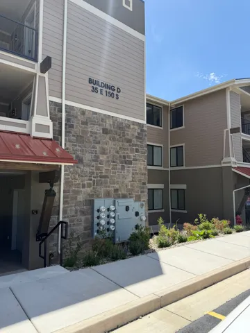 Multi-story building exterior featuring stone façade and horizontal siding