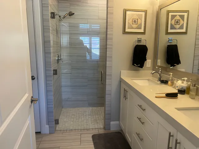 Master Bathroom featuring double vanity, walk or roll in Shower with a bench