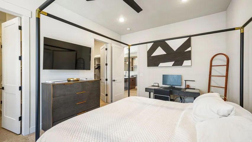 Recessed lighting illuminates this room, featuring a ceiling fan and light-toned walls