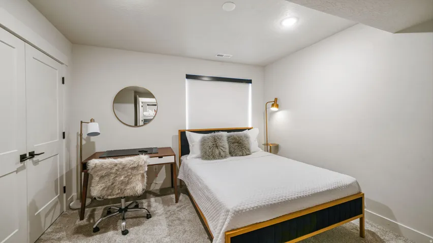 Carpeted room featuring recessed lighting, a window with roller shade, and a desk area