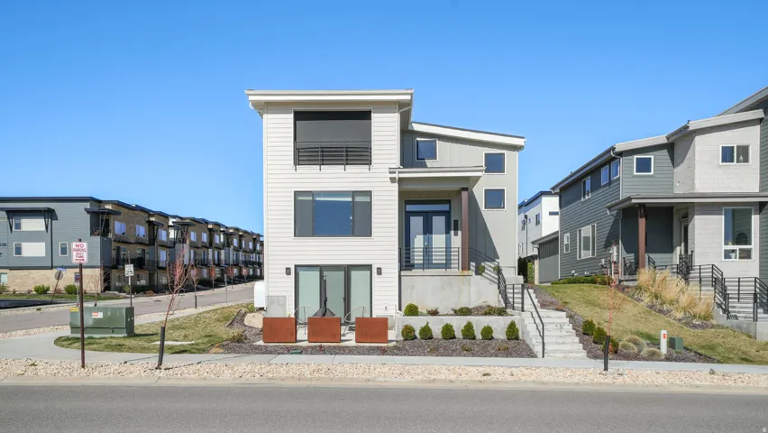 Contemporary multi-level residence featuring a flat roofline and mixed siding