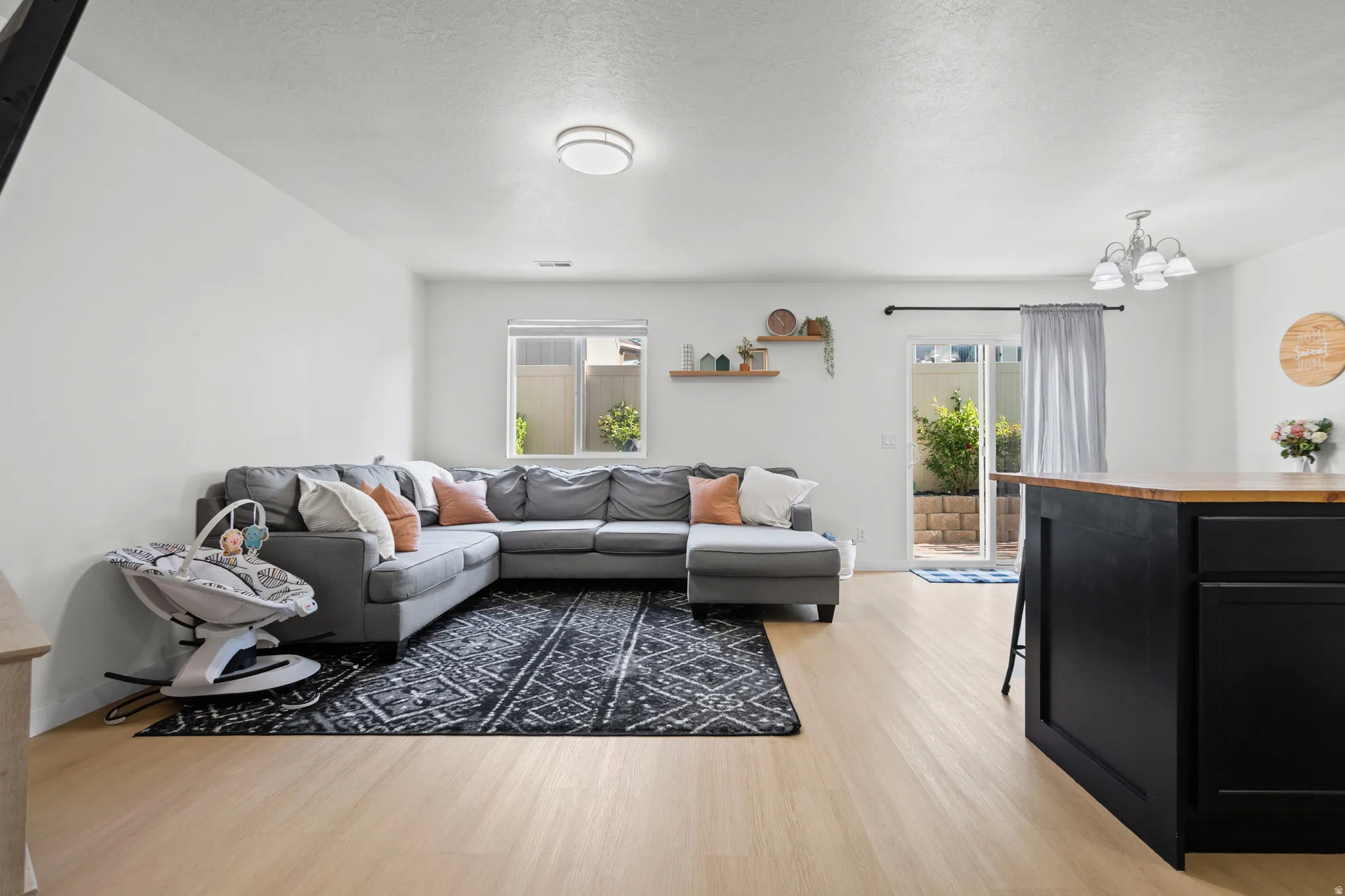 Open concept living area featuring light wood-finish flooring, white walls, and recessed lighting