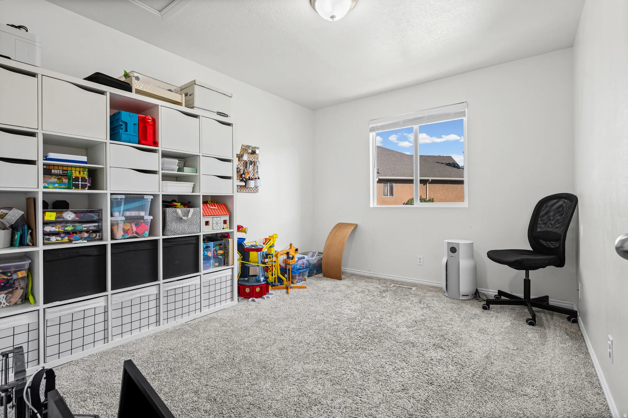 Room featuring light gray wall paint, a double window with white trim, and light gray carpeted flooring