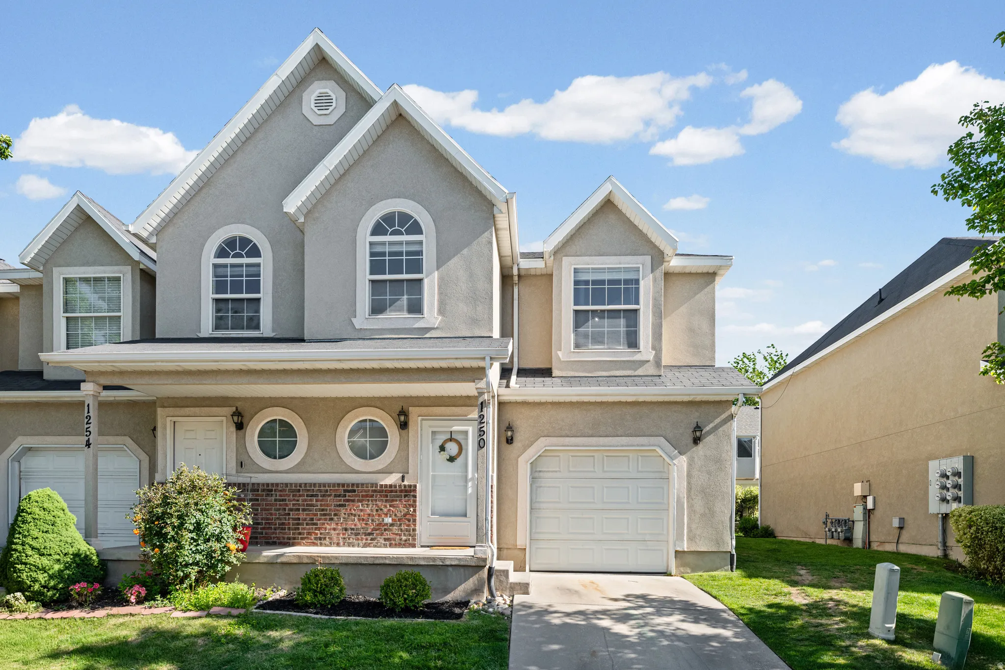 Stucco exterior with gabled roof lines and decorative trim