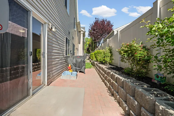 Patio area featuring brick pavers and a concrete slab