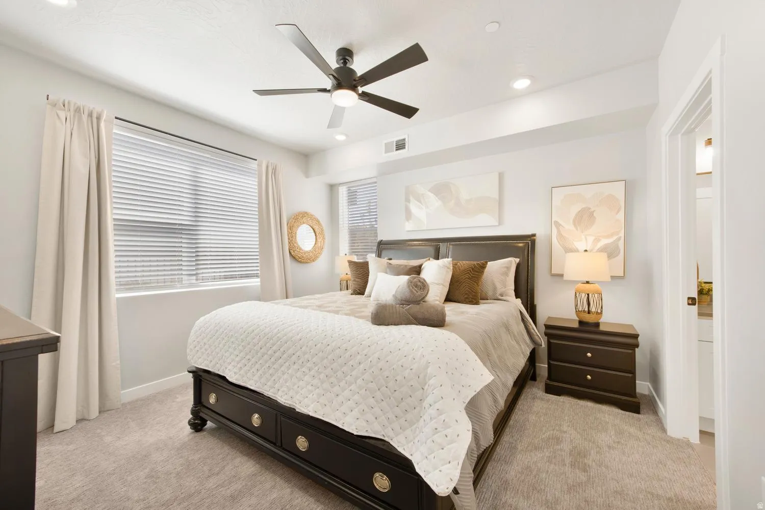 Spacious bedroom featuring plush carpet flooring, a dark wood-finish bed frame, and recessed lighting