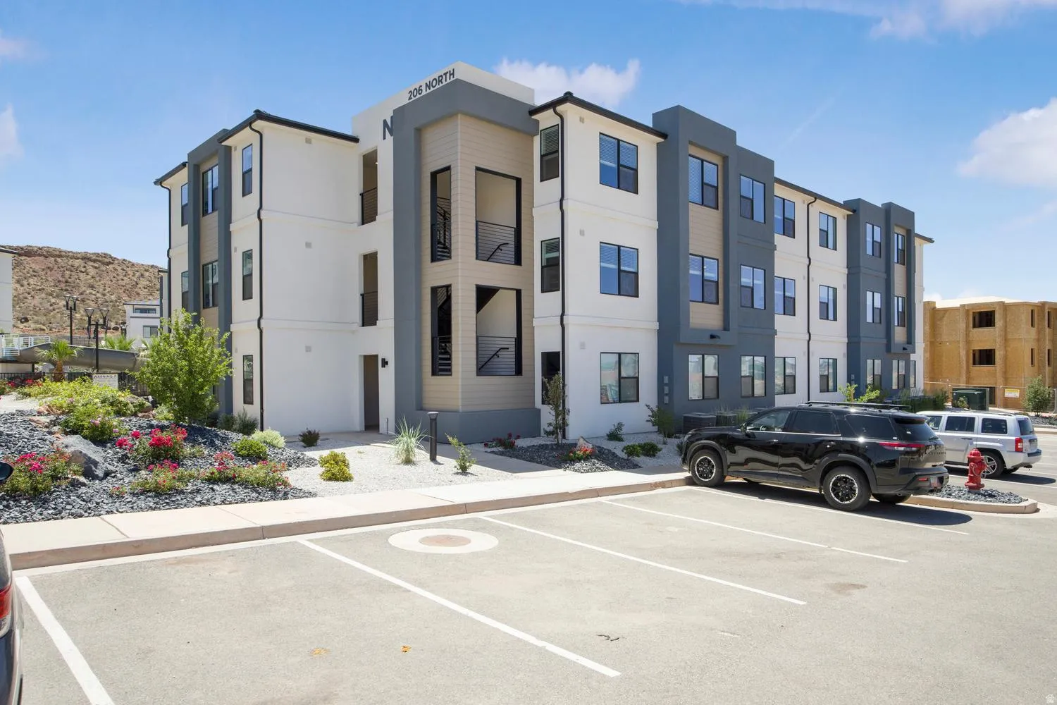 Modern multi-story building featuring a white and dark gray facade with contrasting horizontal siding