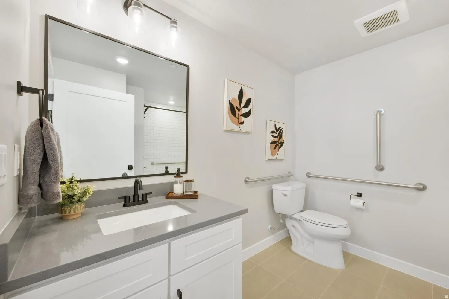 Bathroom featuring a white vanity with a gray countertop, an undermount sink, and black fixtures