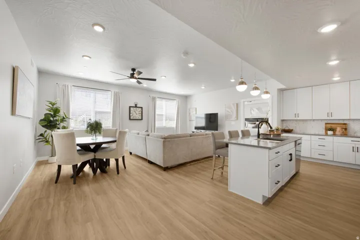 Open-concept living space featuring wood-finish flooring, recessed lighting, and a ceiling fan