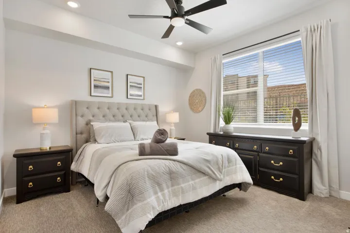 Bedroom featuring a tufted upholstered headboard, recessed lighting, and a ceiling fan