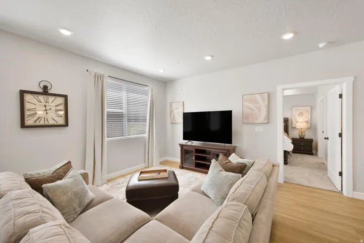Living area featuring recessed lighting, a window with blinds and drapes, and wood-finish flooring