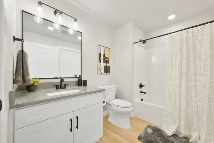 Bathroom featuring a white vanity with shaker-style cabinetry, a gray countertop, and matte black fixtures