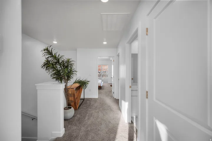 Carpeted hallway featuring recessed lighting and white panel doors