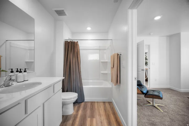 Bathroom featuring a single vanity with a white countertop and undermount sink, chrome faucet, and a mirror
