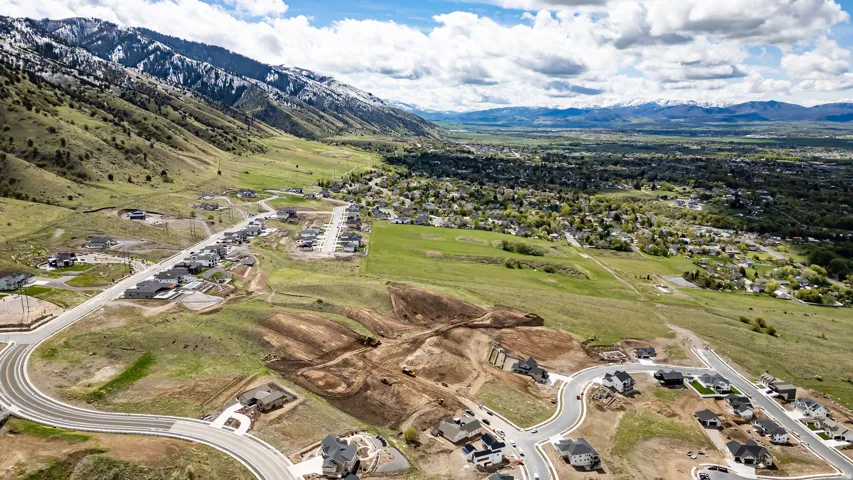 Expansive mountain landscape featuring developing residential areas and established community infrastructure