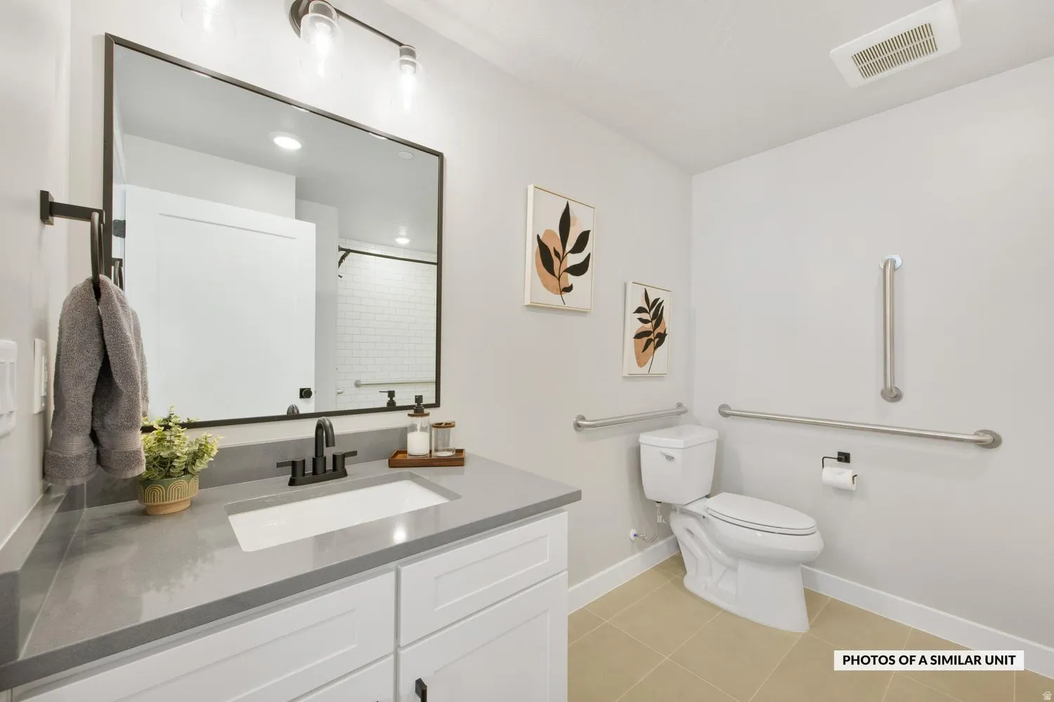 Bathroom featuring a vanity with a light gray countertop, white cabinetry, and a rectangular undermount sink