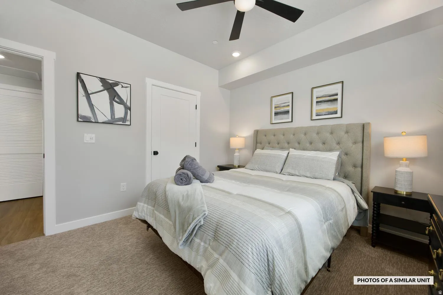 Carpeted bedroom featuring a tray ceiling with recessed lighting and a ceiling fan