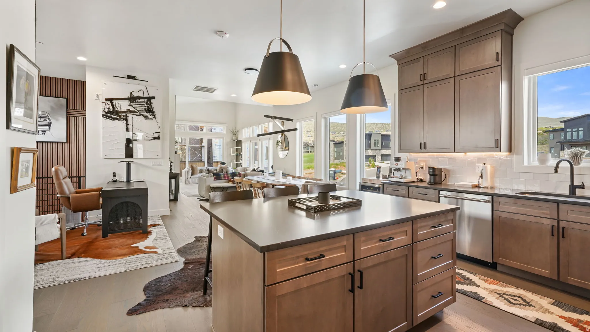 Contemporary kitchen featuring a large central island, full-height cabinetry, stainless steel appliances, and a subway tile backsplash