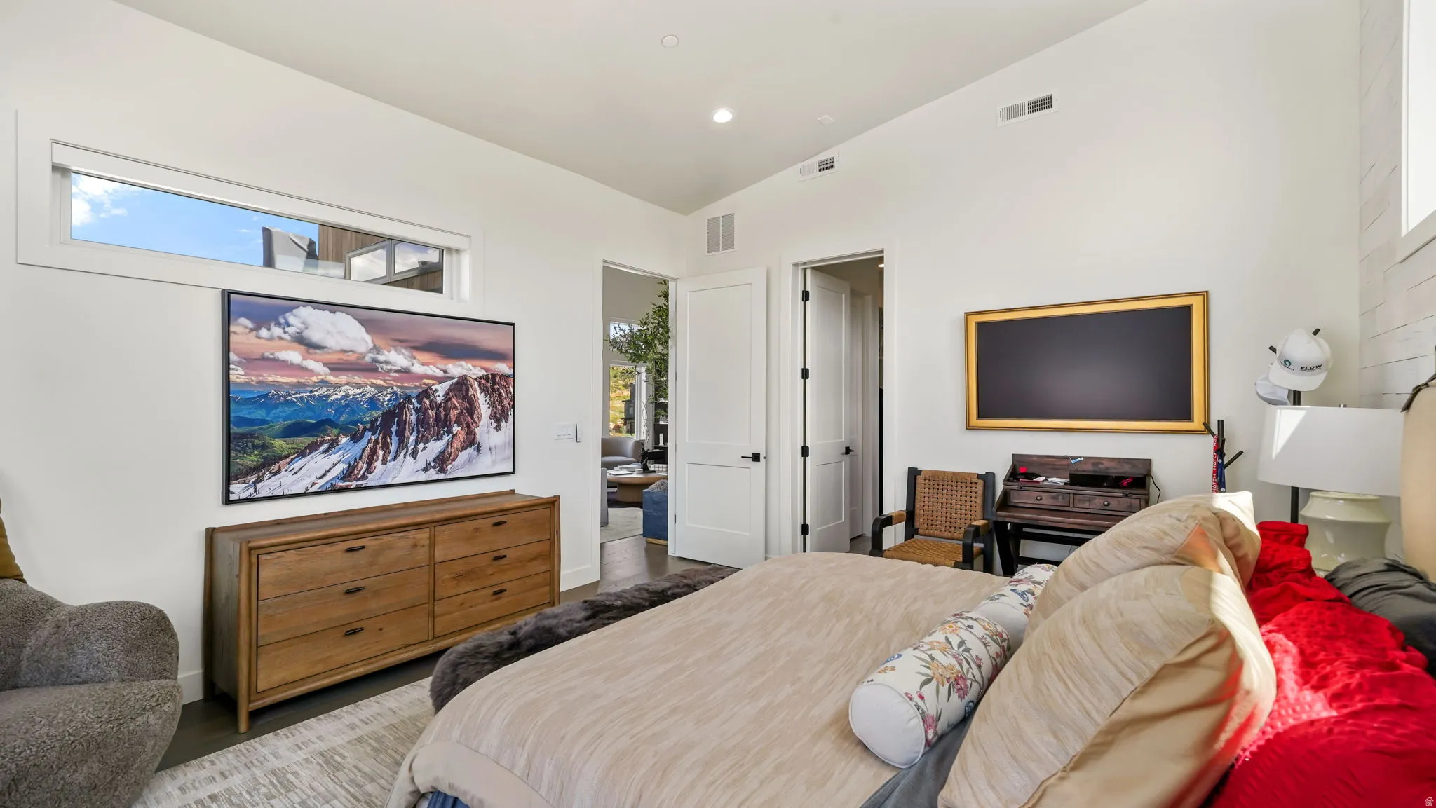 Spacious room featuring white walls and dark wood-finish flooring