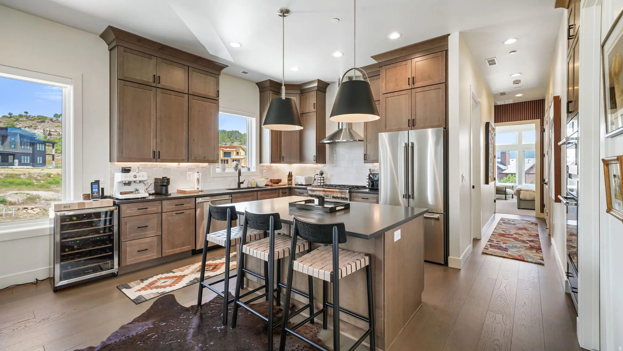 Modern kitchen featuring wood-finish cabinetry, stainless steel appliances, and a central island with bar seating