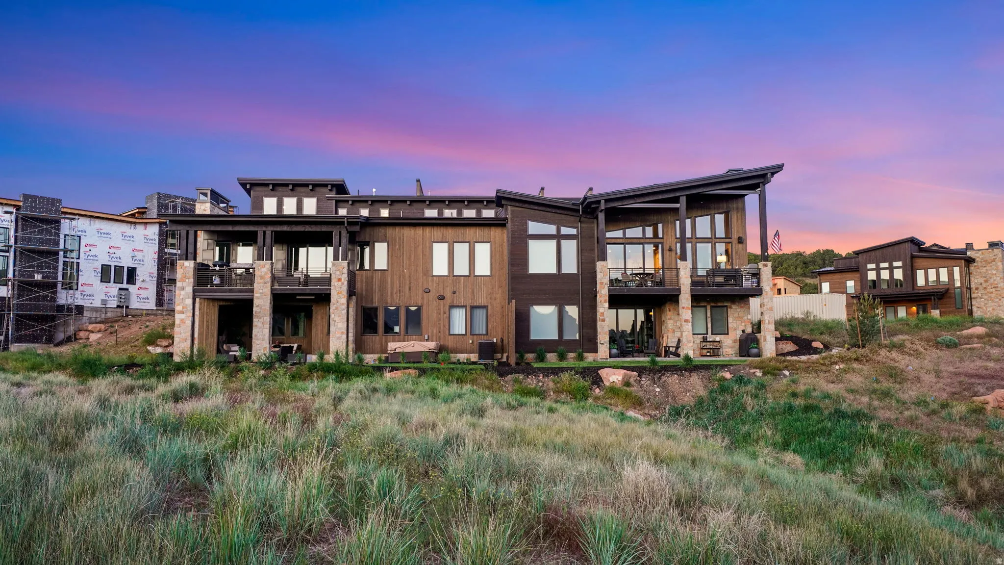 Contemporary multi-level residence featuring dark wood-finish siding and stone accents