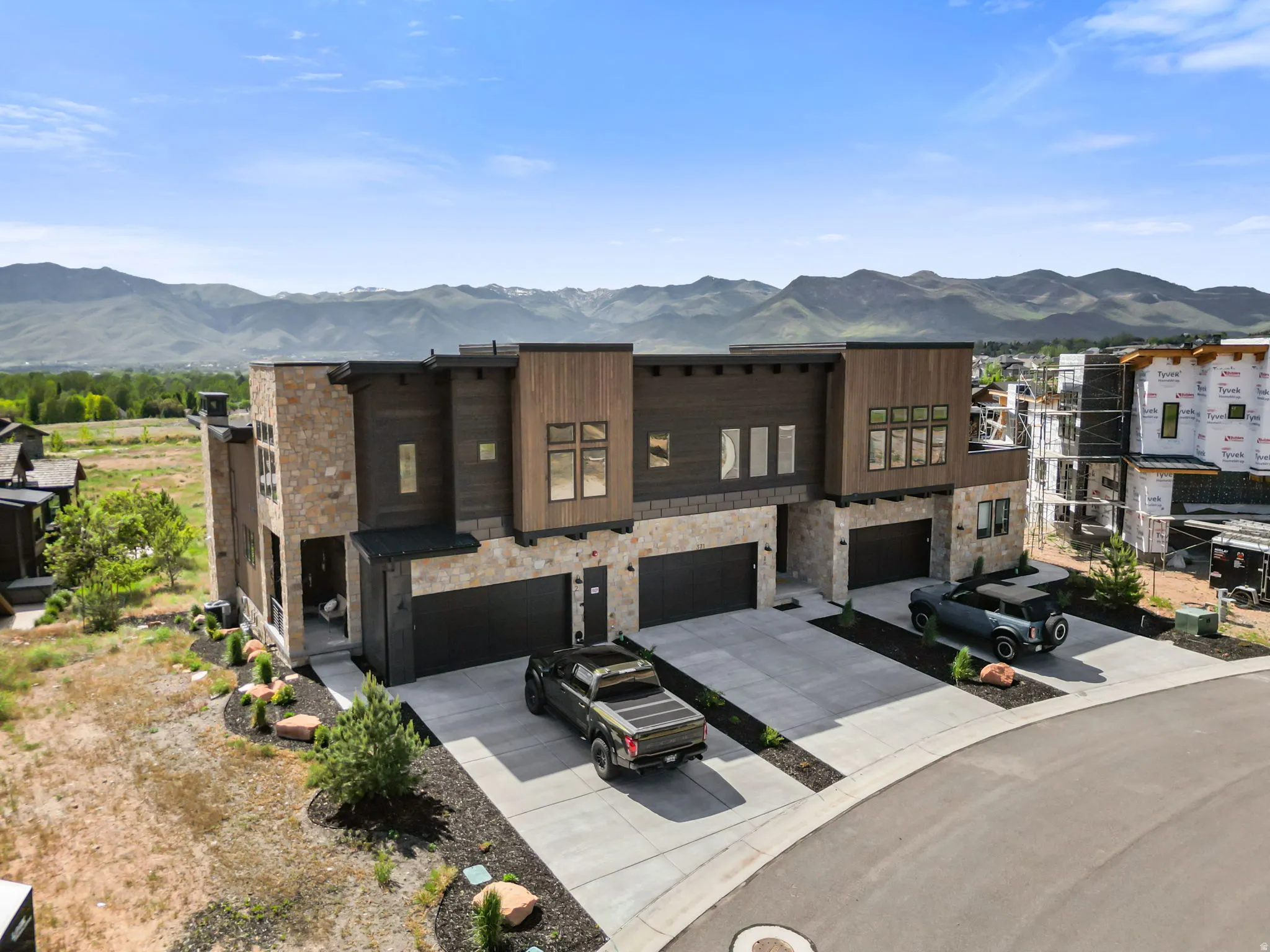 Modern multi-unit residence featuring stone and wood-finish siding with mountain scenery