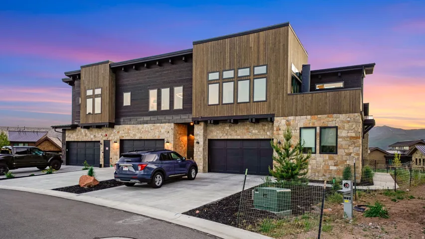 Modern townhome exterior featuring stone and wood-panel accents