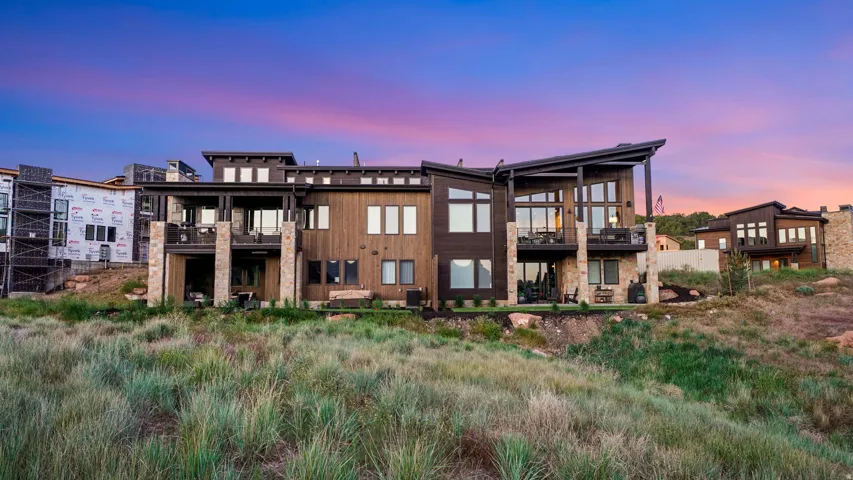 Modern multi-level exterior featuring dark wood-finish siding and stone accents