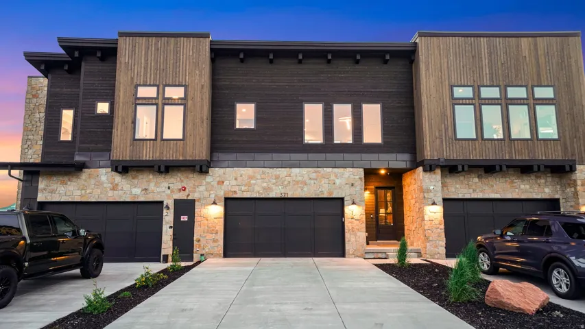 Contemporary facade featuring wood siding and stone accents