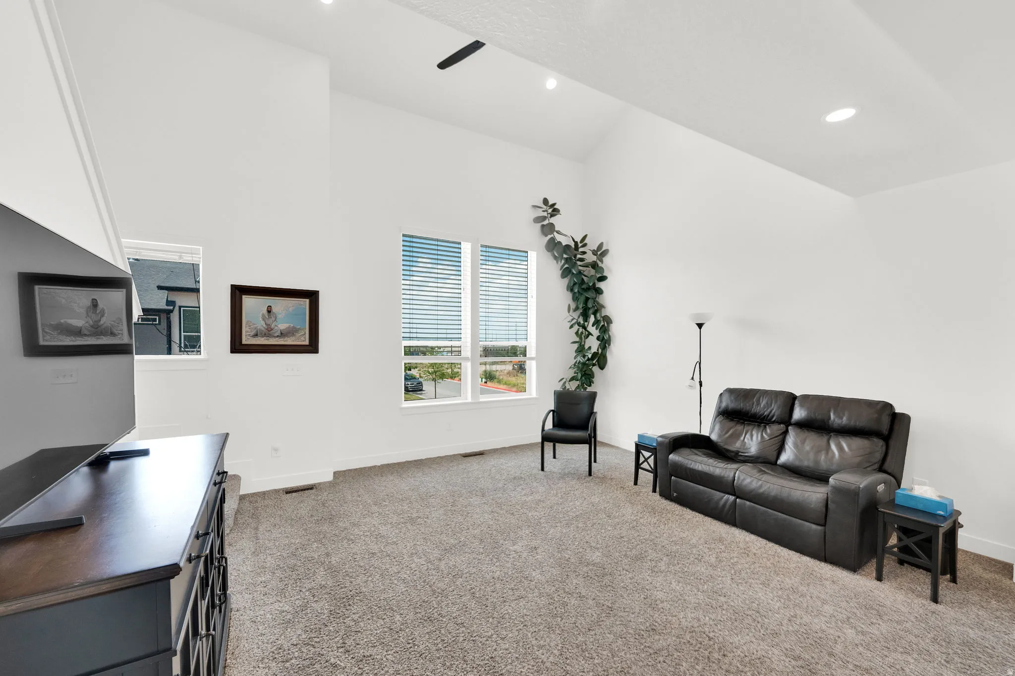 Vaulted ceiling with recessed lighting and a ceiling fan