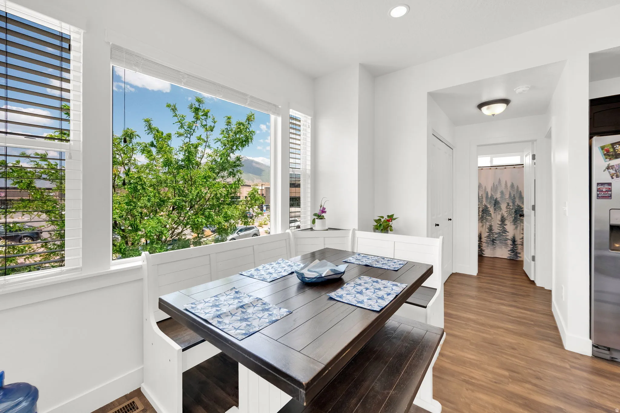 Bright dining nook with expansive windows and mountain scenery