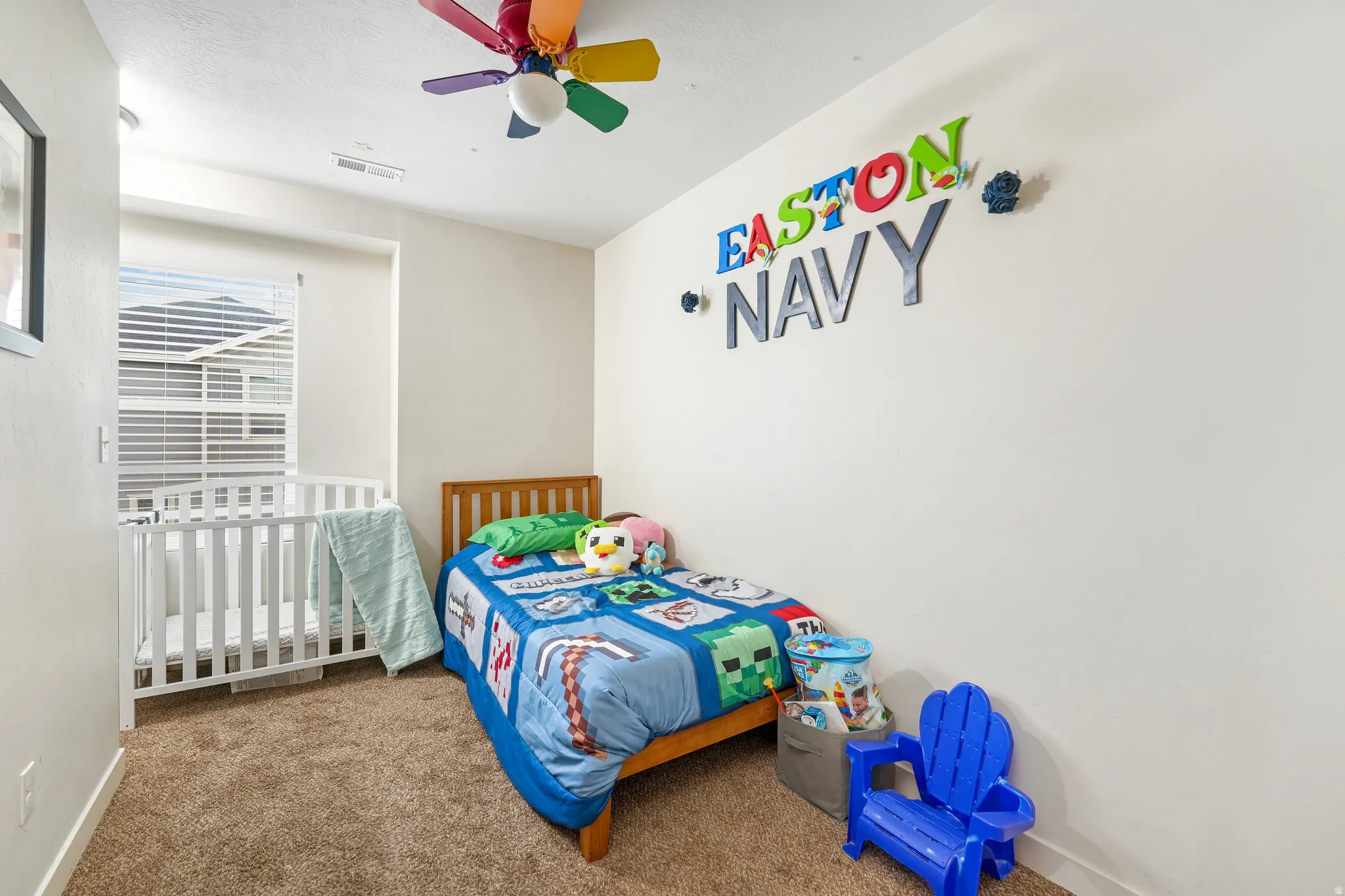 Carpeted room featuring a white interior, a window with horizontal blinds, and a ceiling fan