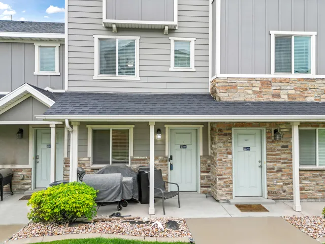Multi-level exterior featuring light gray horizontal siding, natural stone accents, white trim, and a dark shingle roof