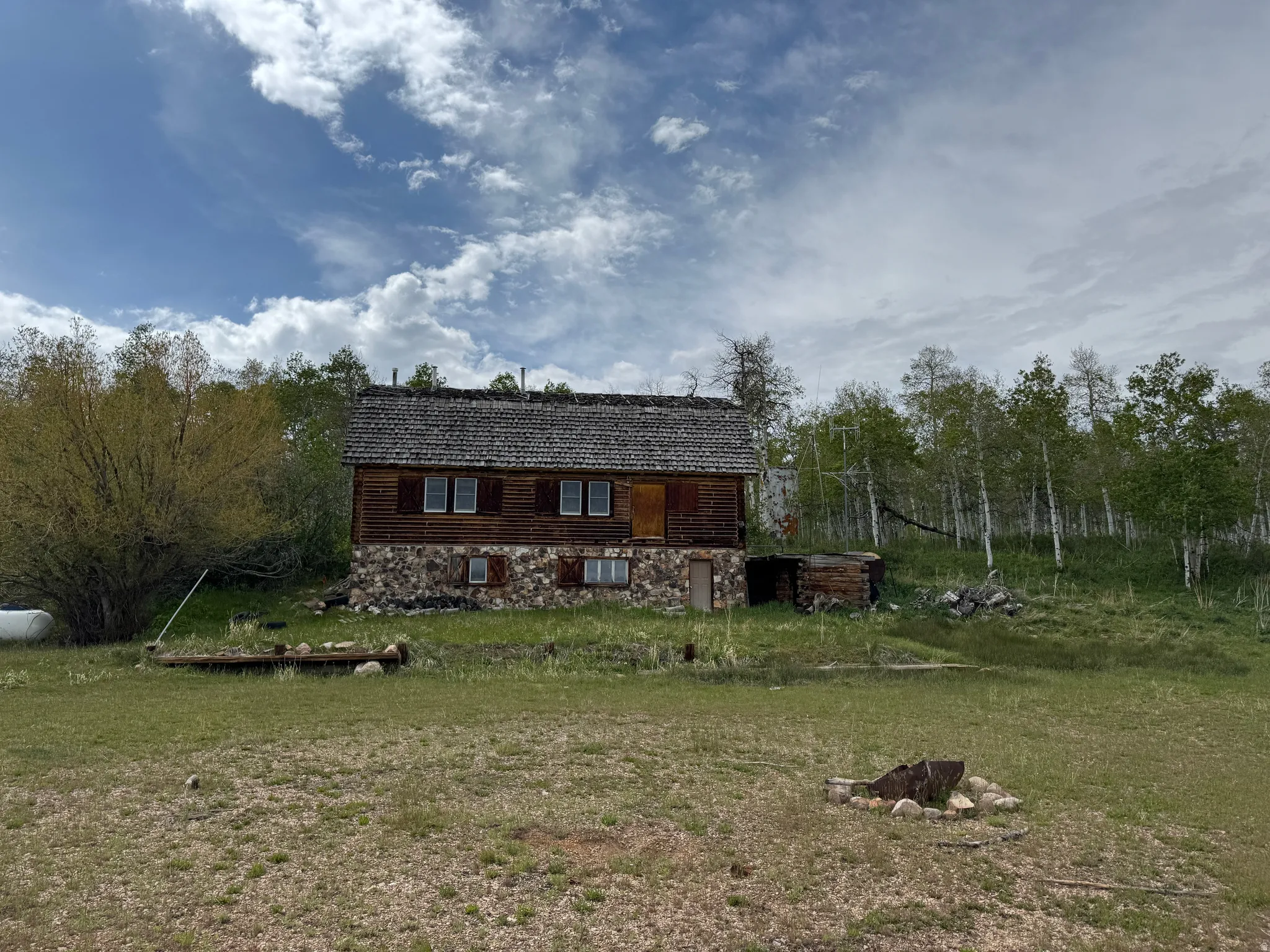 Rustic cabin-style residence featuring a stone foundation and wood siding