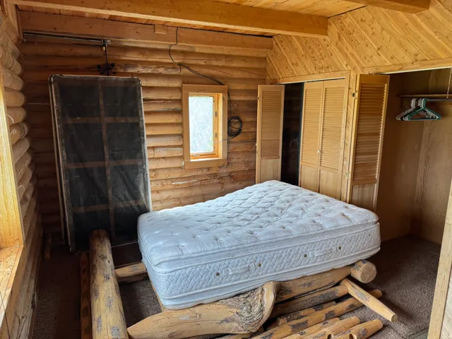 Rustic log construction interior featuring wood-finish walls and slatted bi-fold closet doors