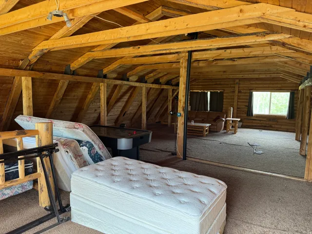 Wood-paneled sloped ceilings in an expansive attic space
