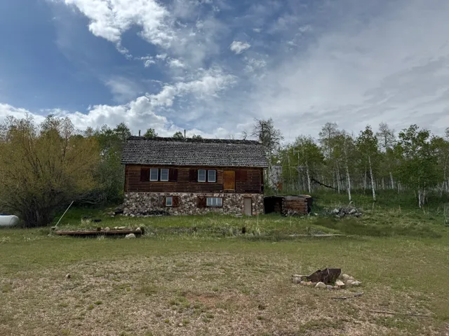 Rustic cabin-style residence featuring a stone foundation and wood siding