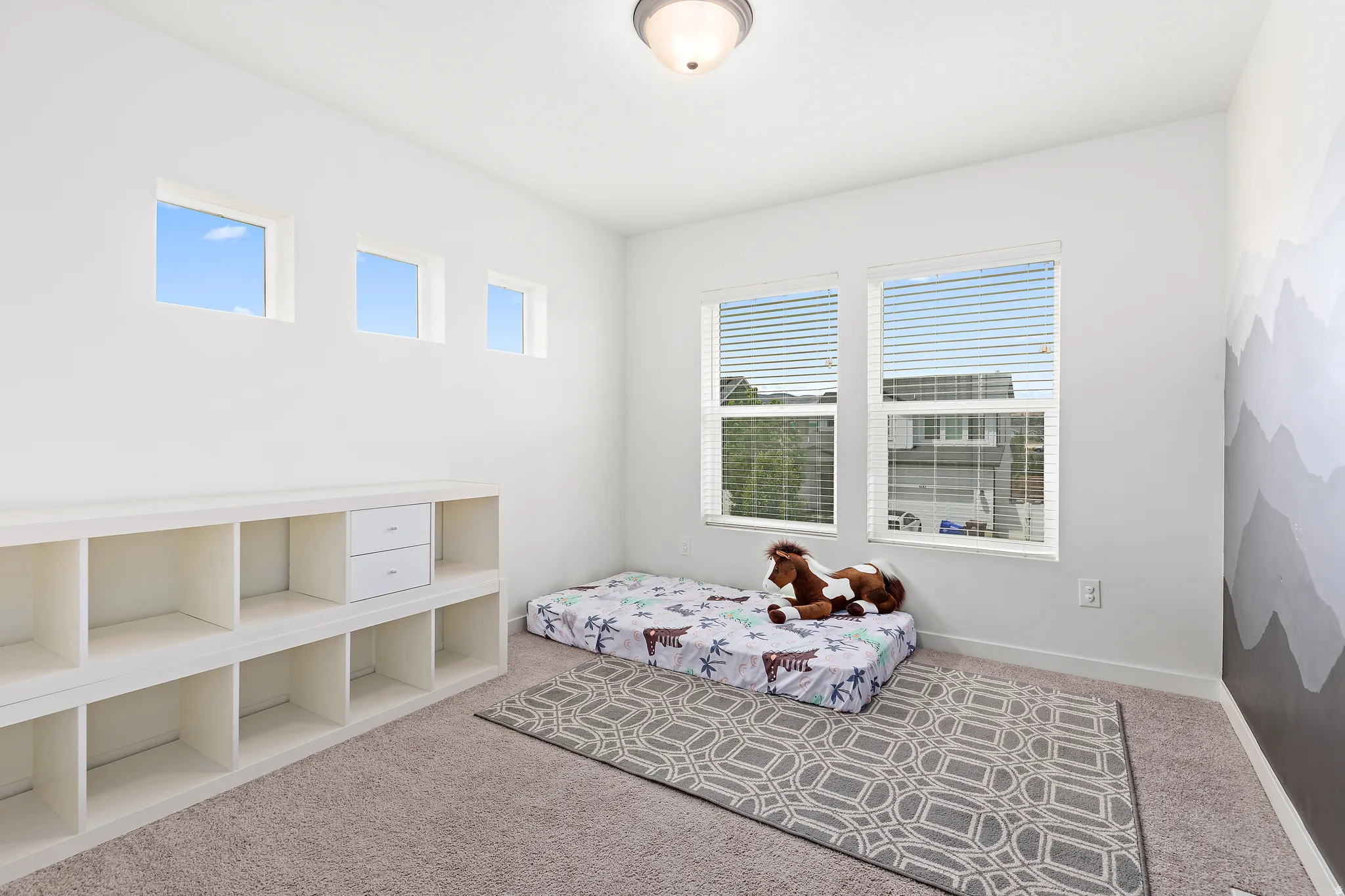 Bright room featuring a series of three square transom windows and two larger rectangular windows