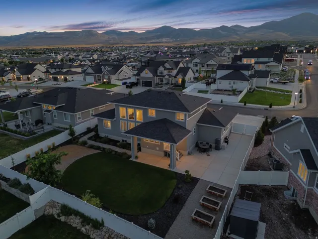Expansive backyard featuring a manicured lawn, paved patio areas, and raised garden beds
