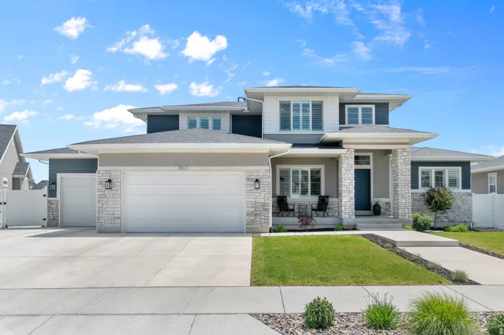 Contemporary two-story residence featuring a blue and white siding exterior with stone accents