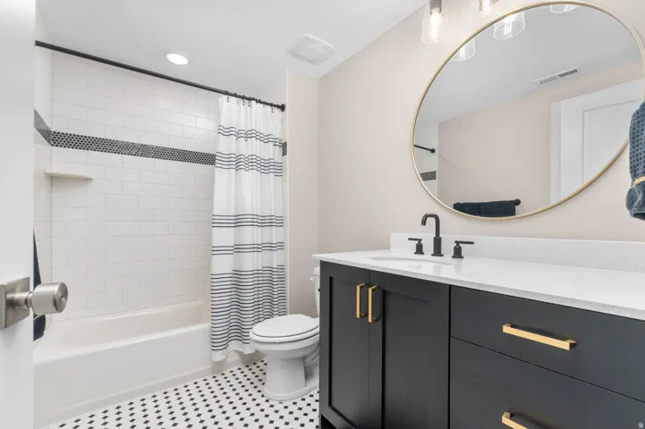 Contemporary bathroom featuring a tub/shower combination with subway tile surround and mosaic accent band