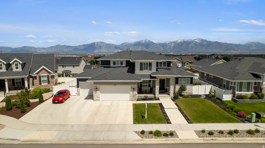 Contemporary residence featuring a light stone and dark siding exterior, a two-car garage, and a concrete driveway