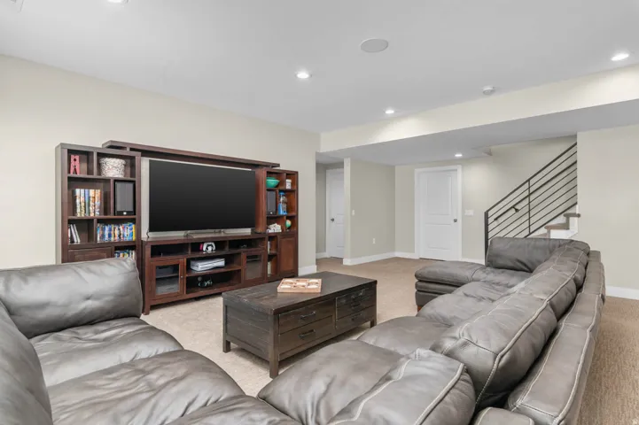 Spacious recreational room with recessed lighting and neutral wall tones