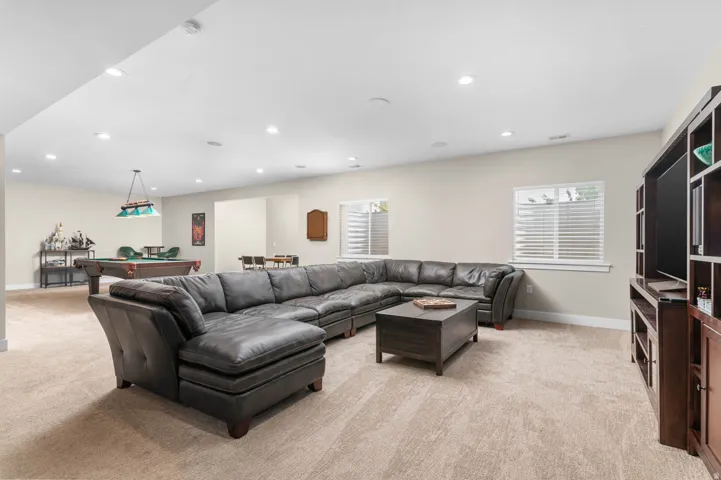 Spacious recreation room featuring recessed lighting, light-toned carpeting, and a built-in media center