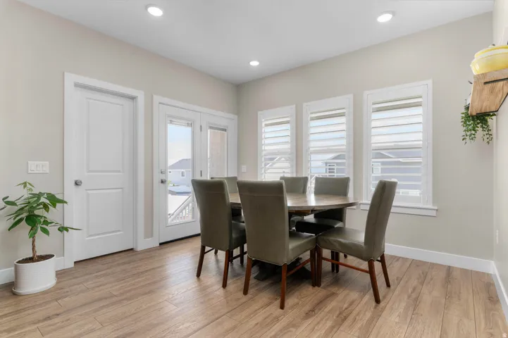 Dining area featuring wood-finish flooring, recessed lighting, white baseboards, and white trim around windows and doors